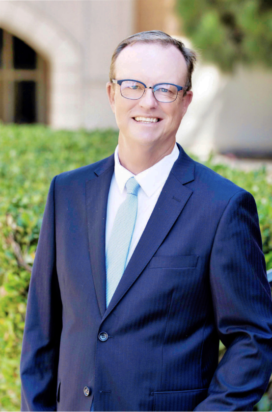 PRINCIPAL JORDAN STANDS outside Loyola Hall