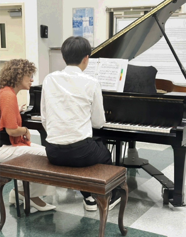 FALIKS GUIDES Martin Kwon '26 in his piano skills