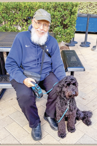FATHER QUINN SITS with Hope the dog